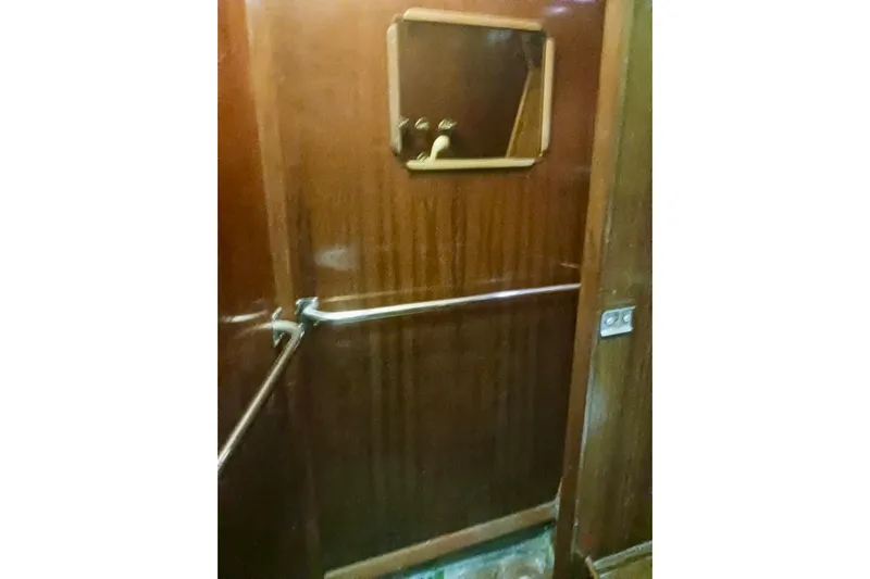 Cloud Chaser Yacht Photos Pics Wood-paneled interior of 1997 Hike Metal Products 67-foot steel ketch, featuring a mirror and handrails.