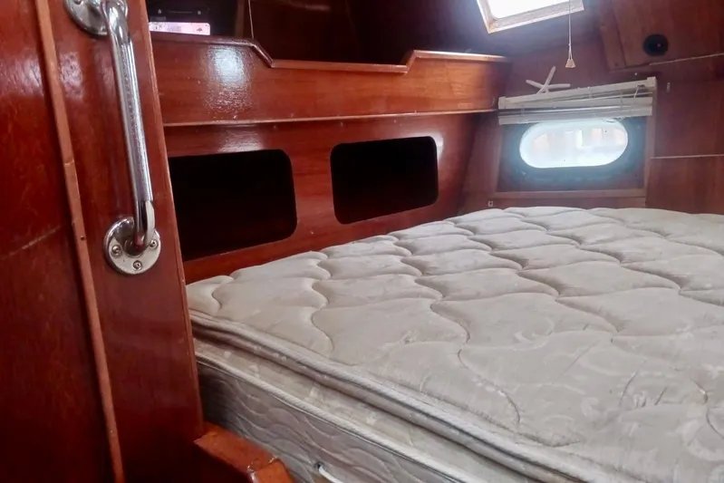 Cloud Chaser Yacht Photos Pics Interior cabin of 1997 Hike Metal Products ketch with wooden finish and mattress.