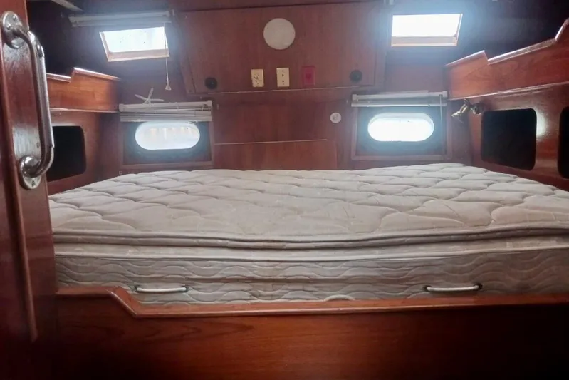 Cloud Chaser Yacht Photos Pics Cozy cabin interior of 1997 Hike Metal Products ketch with wooden finish and mattress.