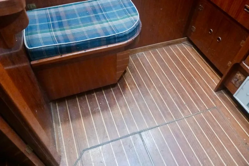 Cloud Chaser Yacht Photos Pics Interior of 1997 Hike Metal Products ketch with wooden flooring and plaid cushioned seating.