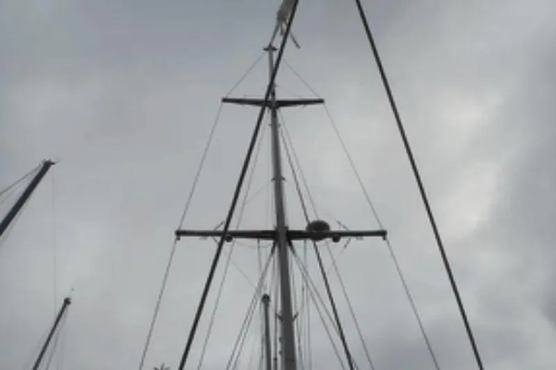 Cloud Chaser Yacht Photos Pics Mast of 1997 Hike Metal Products 67-foot Steel Full-Keel Ketch against cloudy sky.