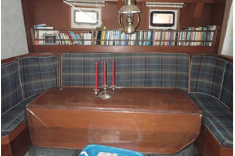 Cloud Chaser Yacht Photos Pics Cozy interior of 1997 Hike Metal Products ketch with plaid seating and bookshelves.