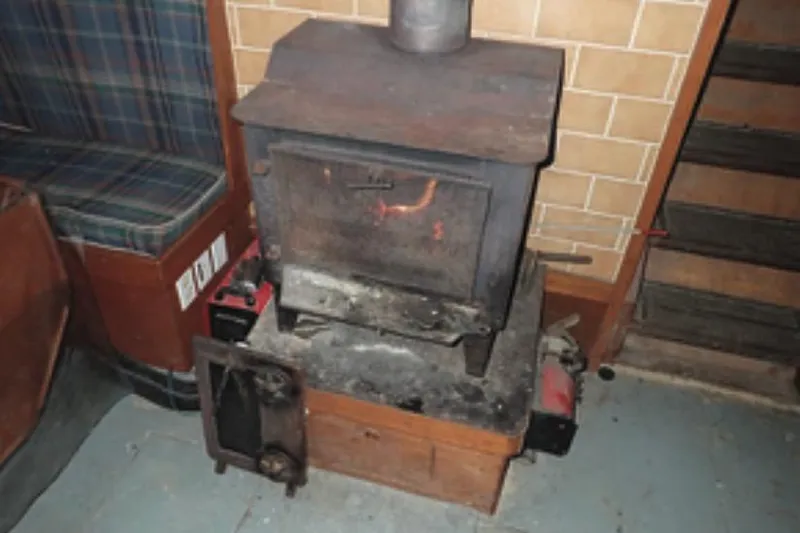 Cloud Chaser Yacht Photos Pics Wood stove inside 1997 Hike Metal Products 67-foot steel ketch, with plaid seating and tiled wall.