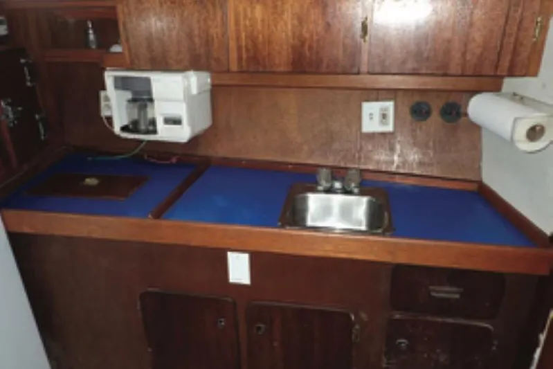 Cloud Chaser Yacht Photos Pics Interior galley of 1997 Hike Metal Products ketch with wooden cabinets and blue countertop.