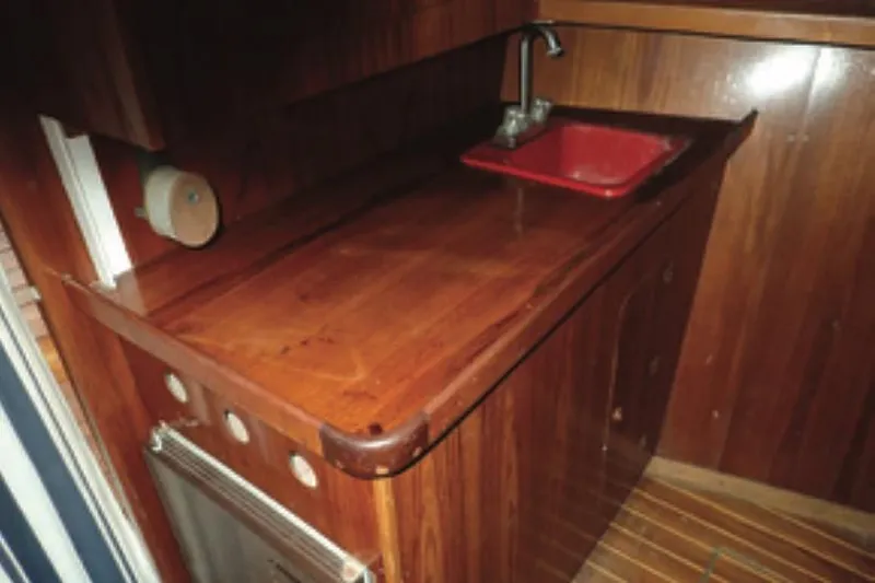 Cloud Chaser Yacht Photos Pics Wooden galley interior of 1997 Hike Metal Products ketch with red sink and faucet.