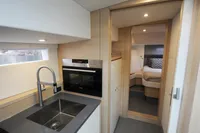 Modern kitchen and cozy bedroom in 2018 Steeler 52s yacht interior.