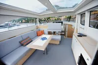 Luxurious interior of 2018 Steeler 52s yacht with panoramic windows and modern seating.