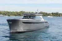 2018 Steeler 52s yacht cruising on a serene blue sea with lush green shoreline.