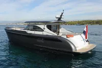 2018 Steeler 52s yacht on calm water, featuring sleek design and flag at stern.
