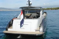 Luxury 2018 Steeler 52s yacht on serene blue waters, rear view with flag.
