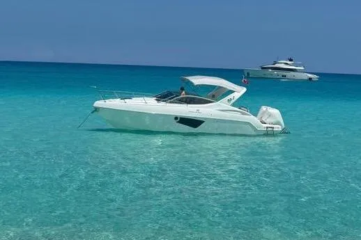 2023 Schaefer 303 Sport boat on clear turquoise water, with another yacht in the background.
