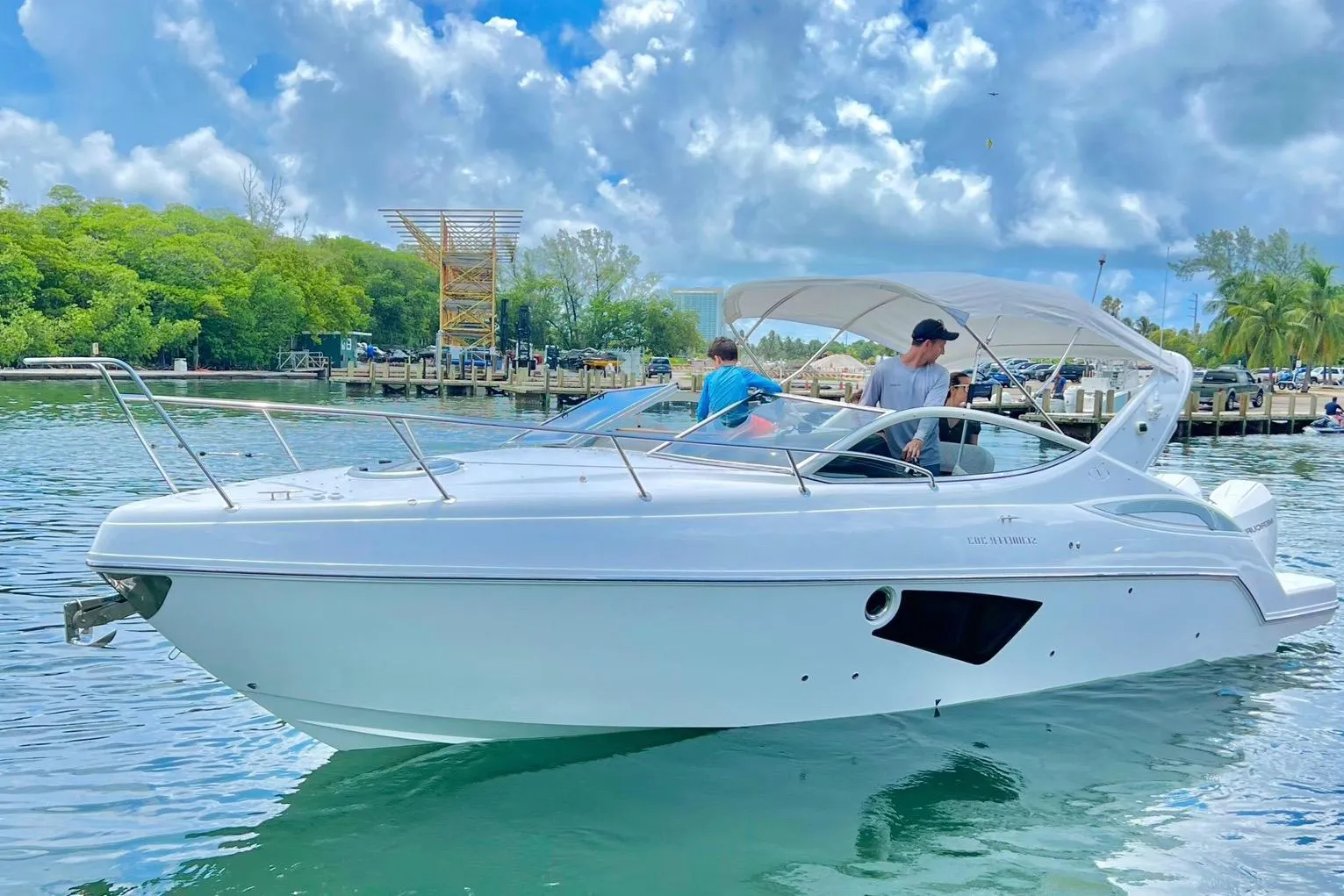 2023 Schaefer 303 Sport boat cruising on a scenic waterway with lush greenery.