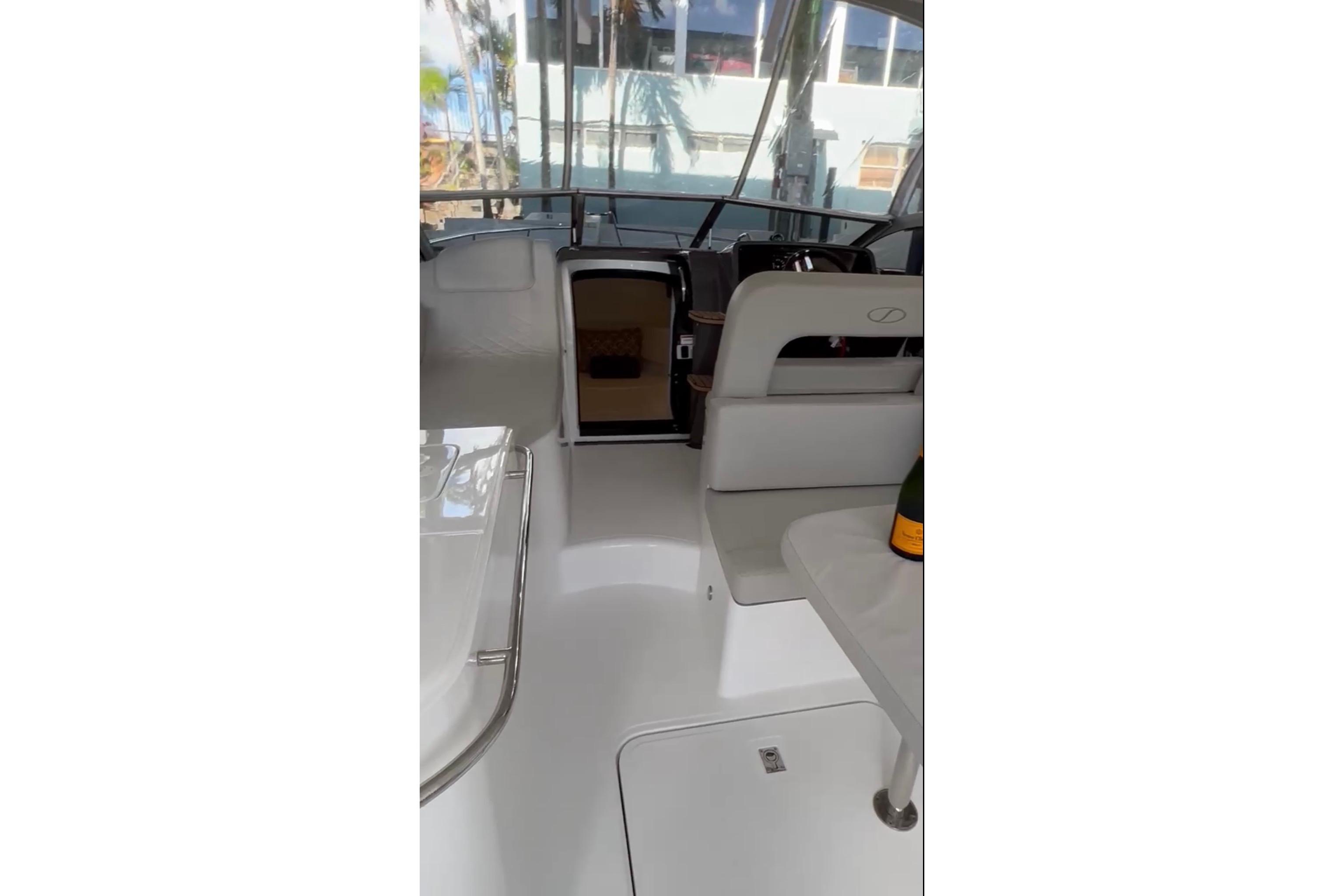 2023 Schaefer 303 Sport boat interior with seating and table, featuring modern design.