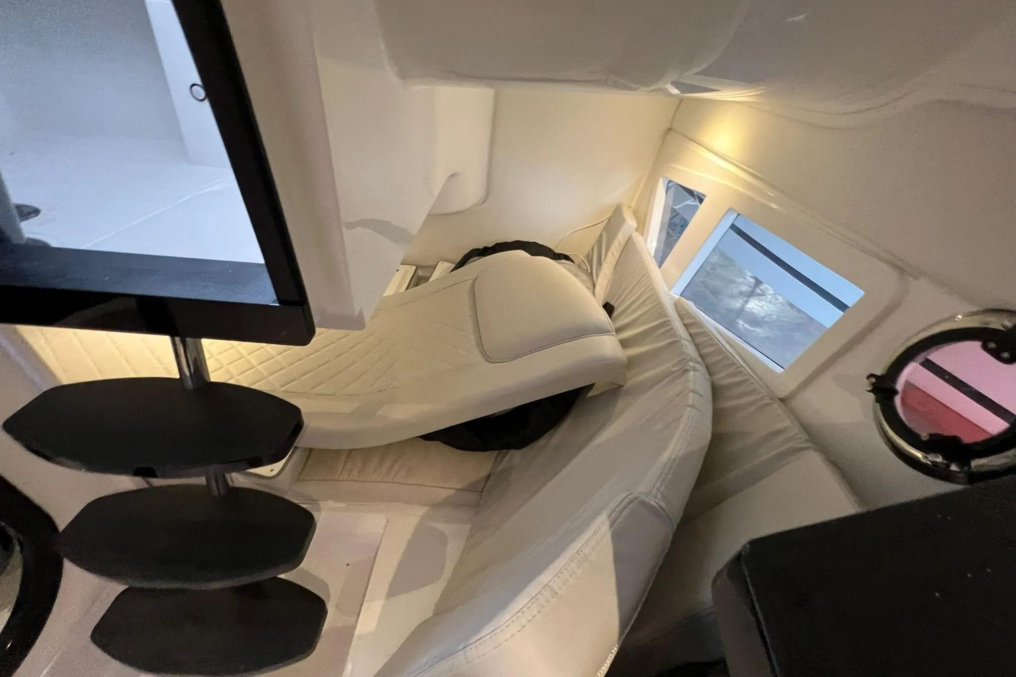 Interior of 2023 Schaefer 303 Sport boat with white seating and windows.