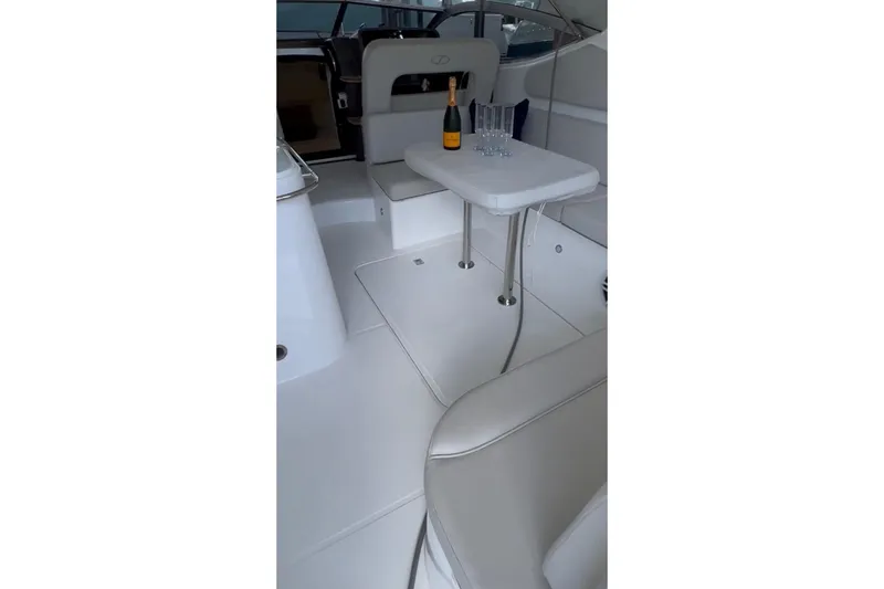  Yacht Photos Pics Interior of 2023 Schaefer 303 Sport yacht with table, champagne, and glasses.