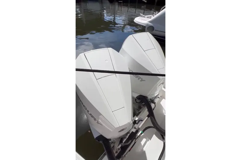  Yacht Photos Pics Twin Mercury outboard engines on a 2023 Schaefer 303 Sport boat, docked by the water.
