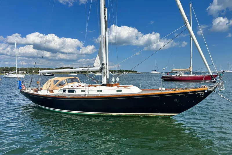 Fandango Yacht Photos Pics 1982 Hinckley Bermuda 40 MK III sailboat on calm water under blue sky.