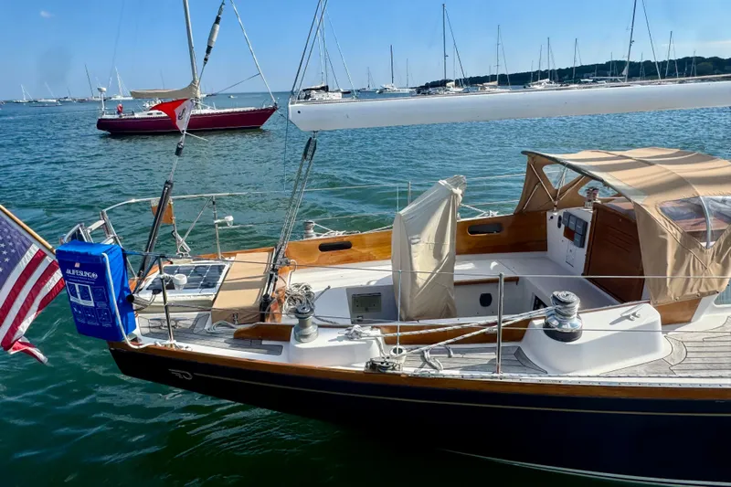 Fandango Yacht Photos Pics Hinckley Bermuda 40 MK III sailboat, 1982 model, docked in a marina with American flag.