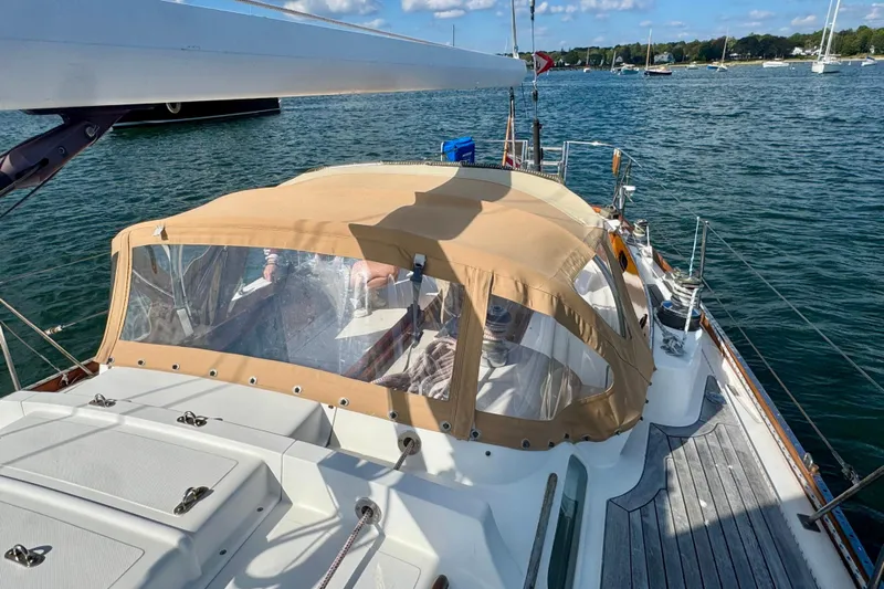 Fandango Yacht Photos Pics Hinckley Bermuda 40 MK III sailboat, 1982 model, with tan canopy on calm waters.