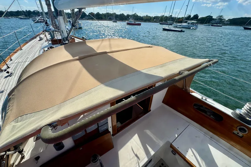 Fandango Yacht Photos Pics 1982 Hinckley Bermuda 40 MK III sailboat with tan canopy, docked on a sunny day.