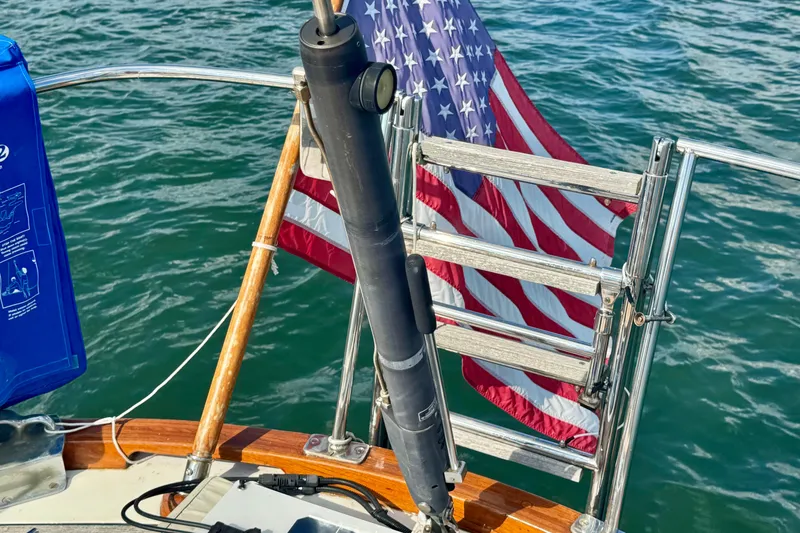 Fandango Yacht Photos Pics Hinckley Bermuda 40 MK III sailboat, 1982, with American flag and ocean backdrop.