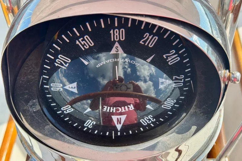 Fandango Yacht Photos Pics Compass on 1982 Hinckley Bermuda 40 MK III sailboat, reflecting sky and clouds.