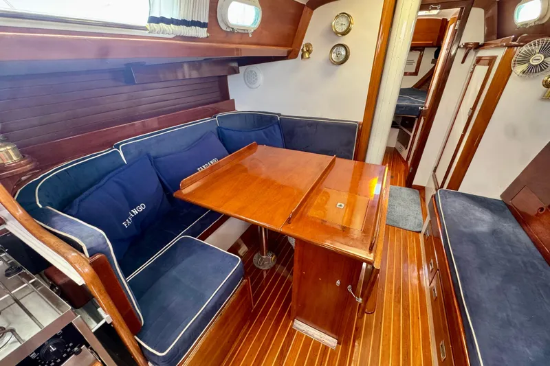 Fandango Yacht Photos Pics Interior of 1982 Hinckley Bermuda 40 MK III with wooden table and blue seating.