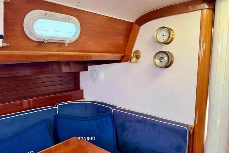 Fandango Yacht Photos Pics Interior of 1982 Hinckley Bermuda 40 MK III with blue cushions and brass instruments.