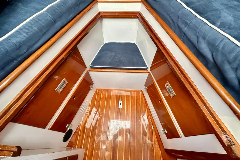 Fandango Yacht Photos Pics Interior of 1982 Hinckley Bermuda 40 MK III sailboat with wood finish and blue cushions.