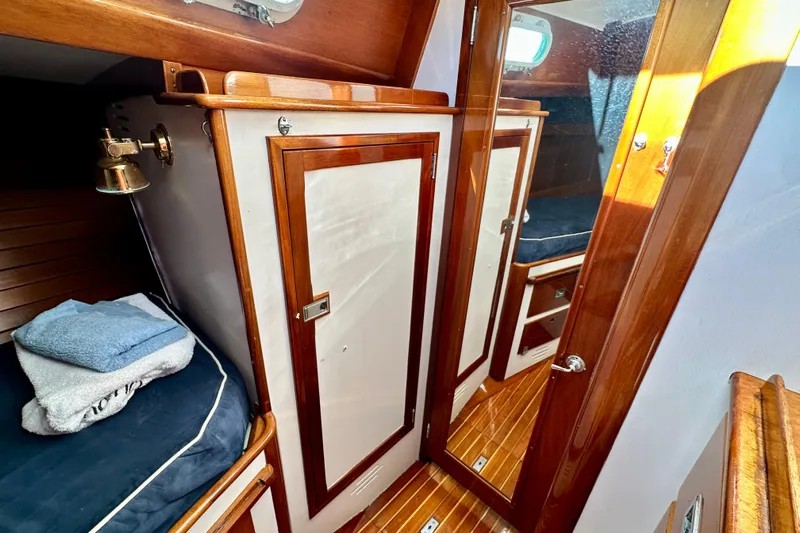 Fandango Yacht Photos Pics Interior of 1982 Hinckley Bermuda 40 MK III sailboat with wooden cabinetry and cozy sleeping area.