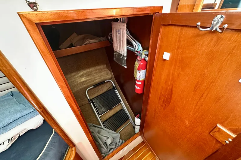 Fandango Yacht Photos Pics Wooden closet interior on 1982 Hinckley Bermuda 40 MK III yacht, featuring fire extinguisher and step ladder.