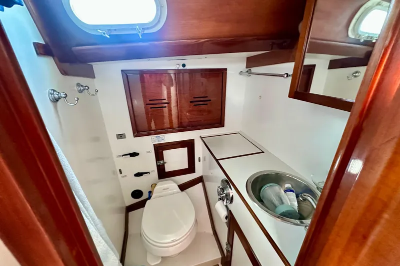 Fandango Yacht Photos Pics 1982 Hinckley Bermuda 40 MK III yacht bathroom with wooden cabinetry and compact sink.