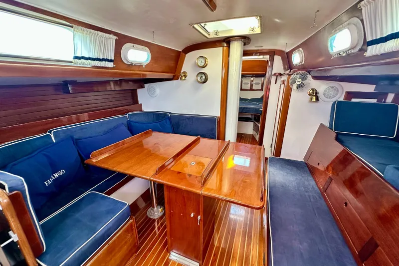 Fandango Yacht Photos Pics Interior of 1982 Hinckley Bermuda 40 MK III sailboat with wooden furnishings and blue seating.