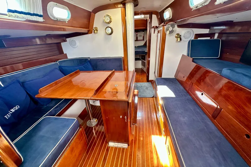 Fandango Yacht Photos Pics Interior of 1982 Hinckley Bermuda 40 MK III sailboat with wooden finishes and blue seating.