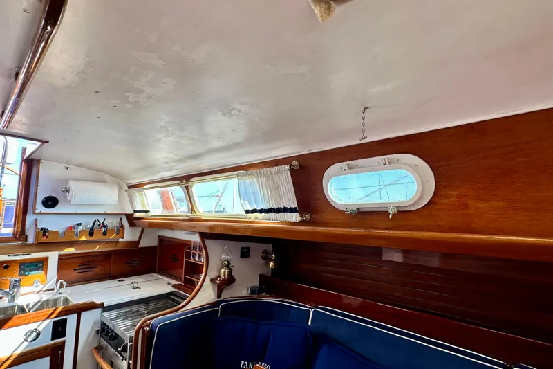 Fandango Yacht Photos Pics Interior of 1982 Hinckley Bermuda 40 MK III sailboat with wood paneling and kitchen area.