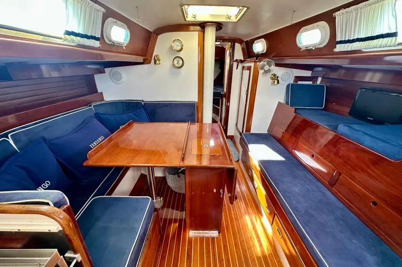 Fandango Yacht Photos Pics Interior of 1982 Hinckley Bermuda 40 MK III sailboat with wooden finishes and blue seating.