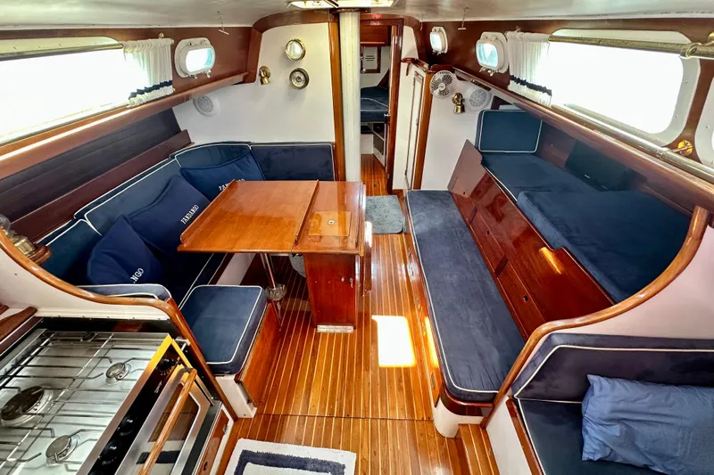 Fandango Yacht Photos Pics Interior of 1982 Hinckley Bermuda 40 MK III sailboat with wood finishes and blue seating.