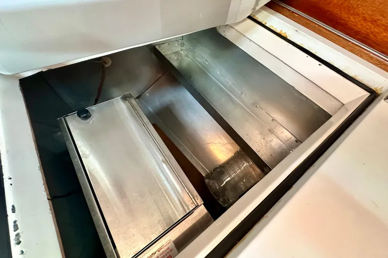 Fandango Yacht Photos Pics Storage compartment inside 1982 Hinckley Bermuda 40 MK III sailboat, featuring metal containers.