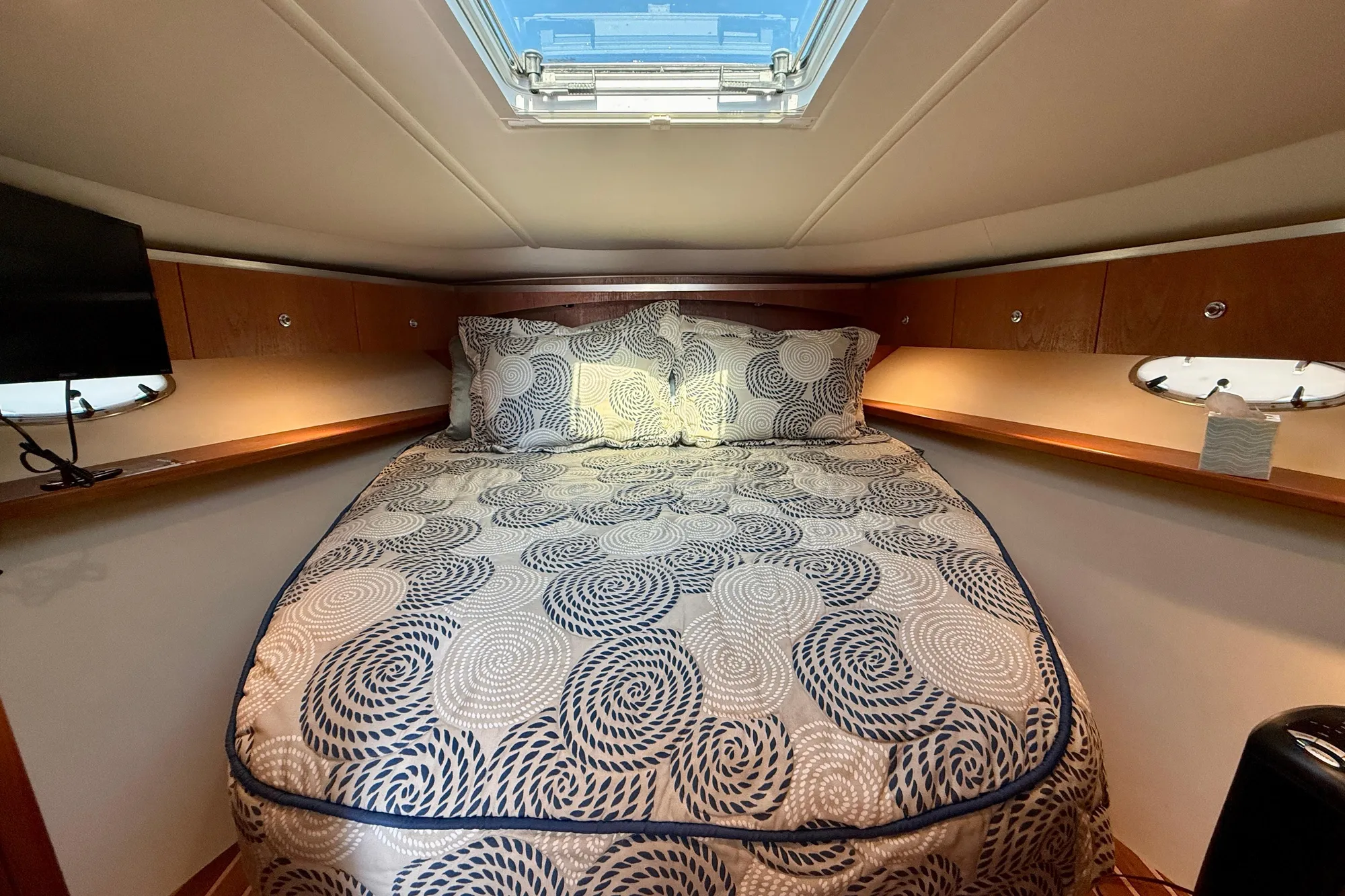 Luxurious cabin interior of 2005 Tiara 3600 Open yacht with patterned bedding.