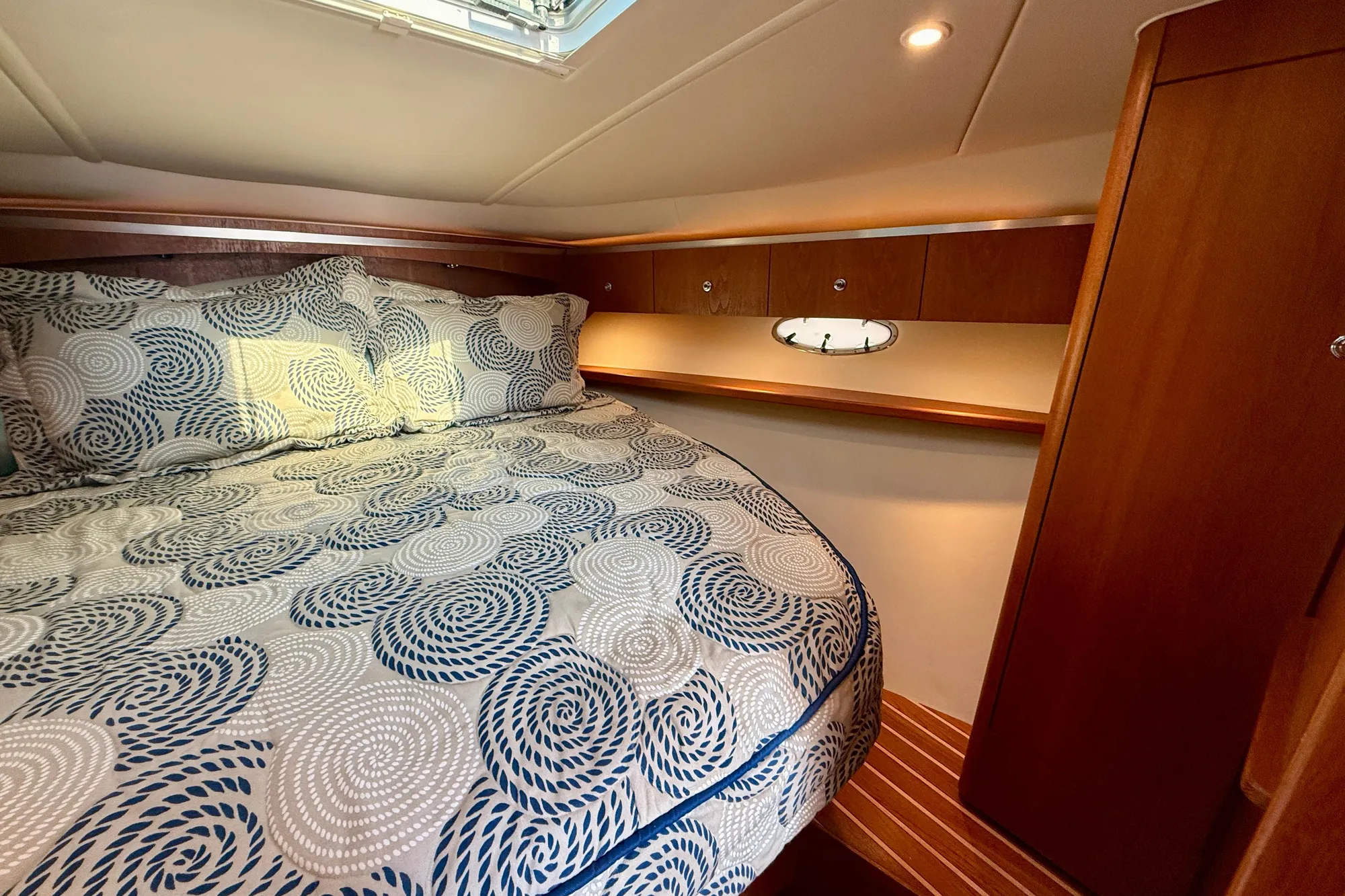 Luxurious cabin interior of 2005 Tiara 3600 Open yacht with patterned bedding.