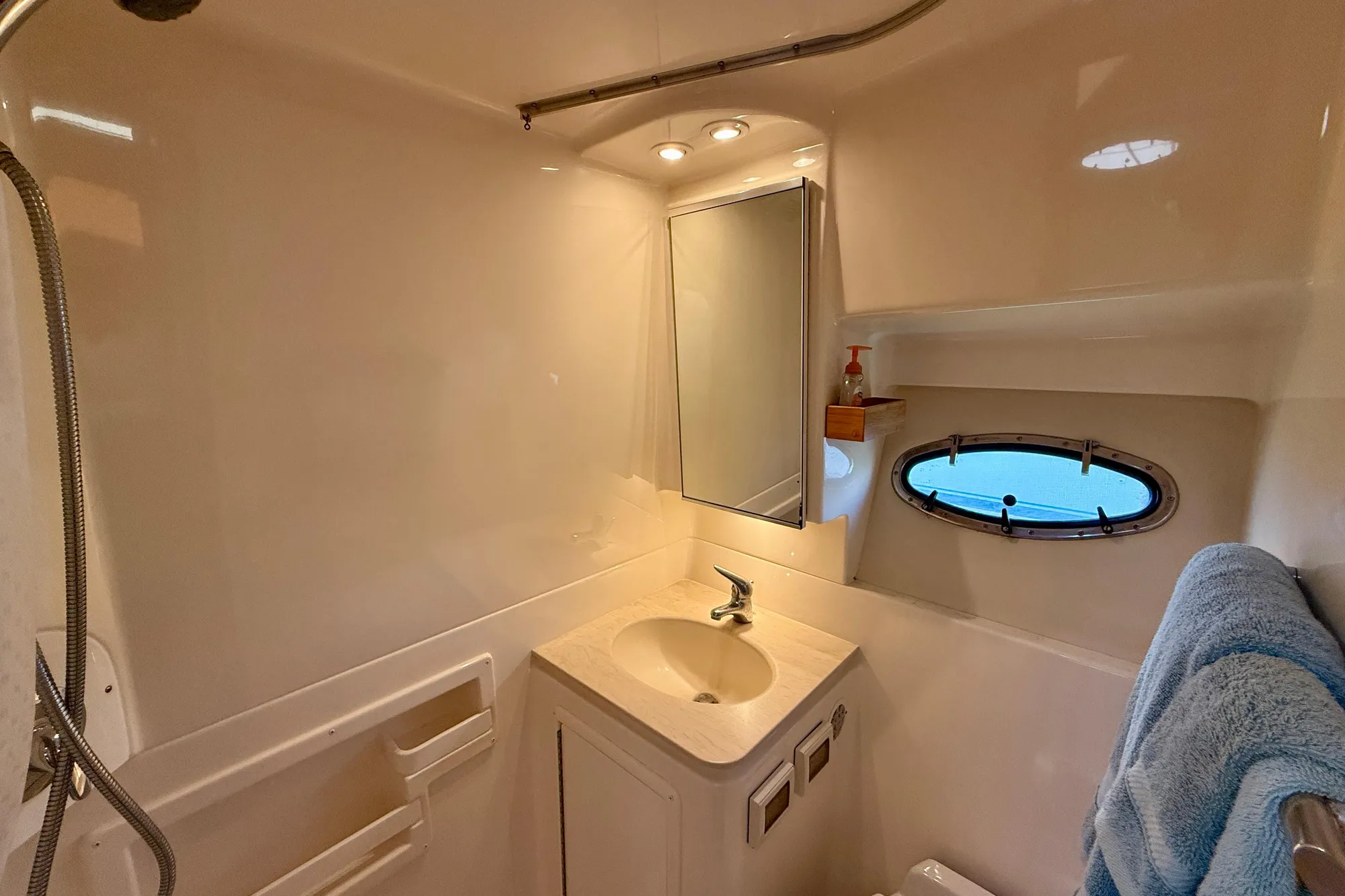 Bathroom interior of 2005 Tiara 3600 Open yacht with sink and porthole.
