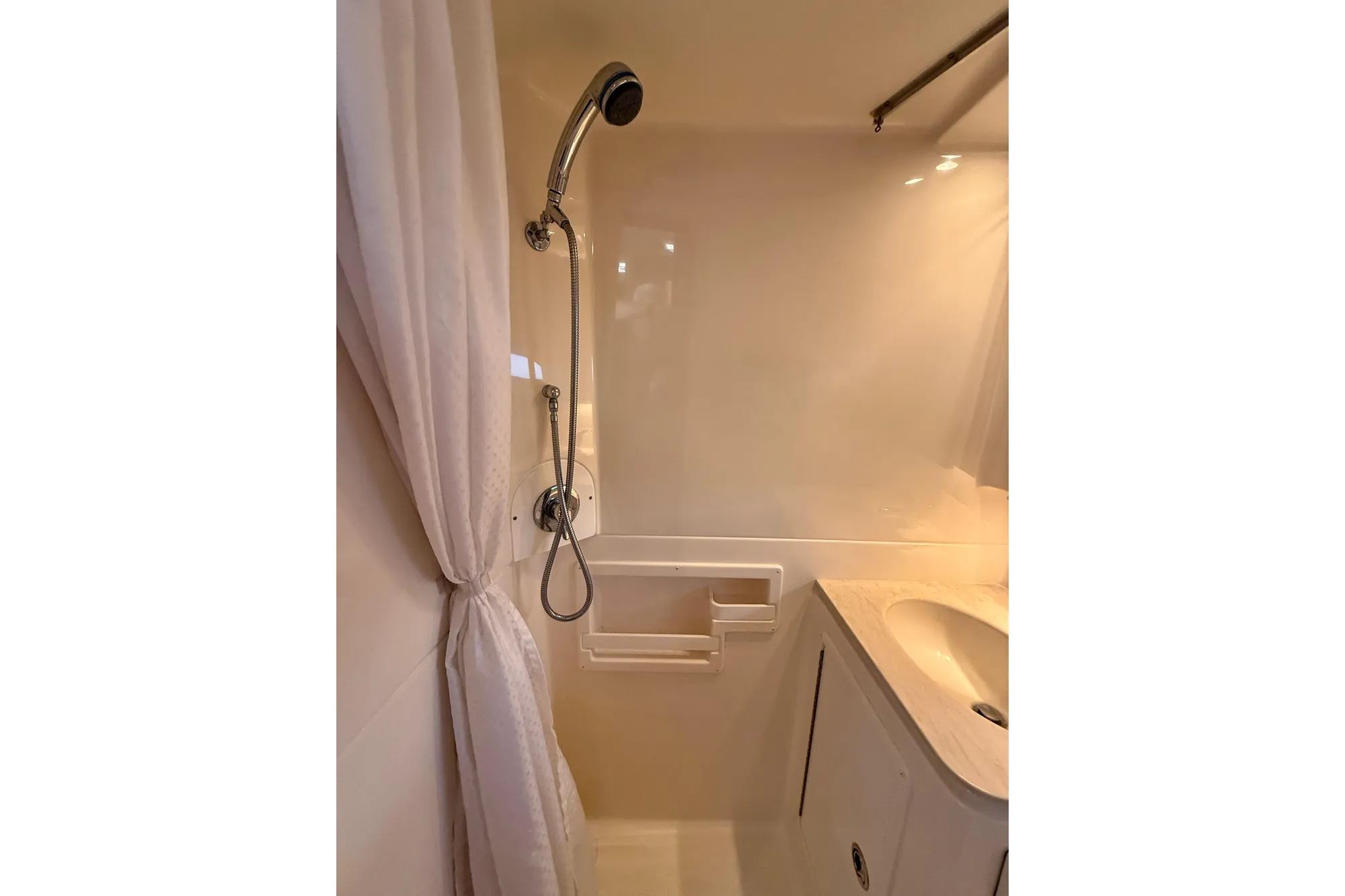 Compact shower area in 2005 Tiara 3600 Open yacht, featuring handheld showerhead and curtain.