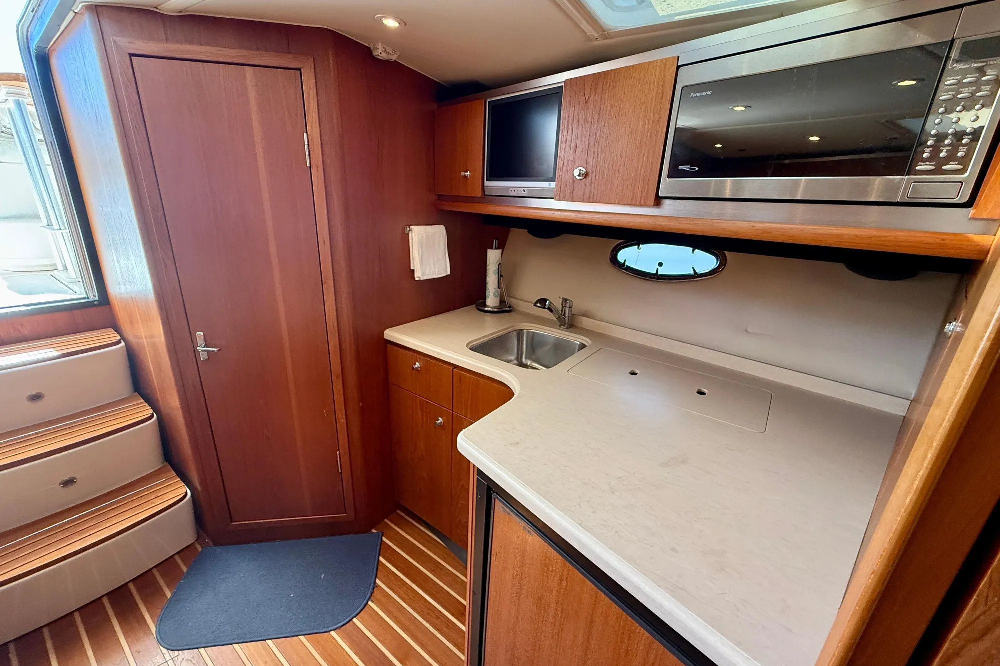 2005 Tiara 3600 Open yacht interior with kitchenette, featuring wood cabinetry and modern appliances.