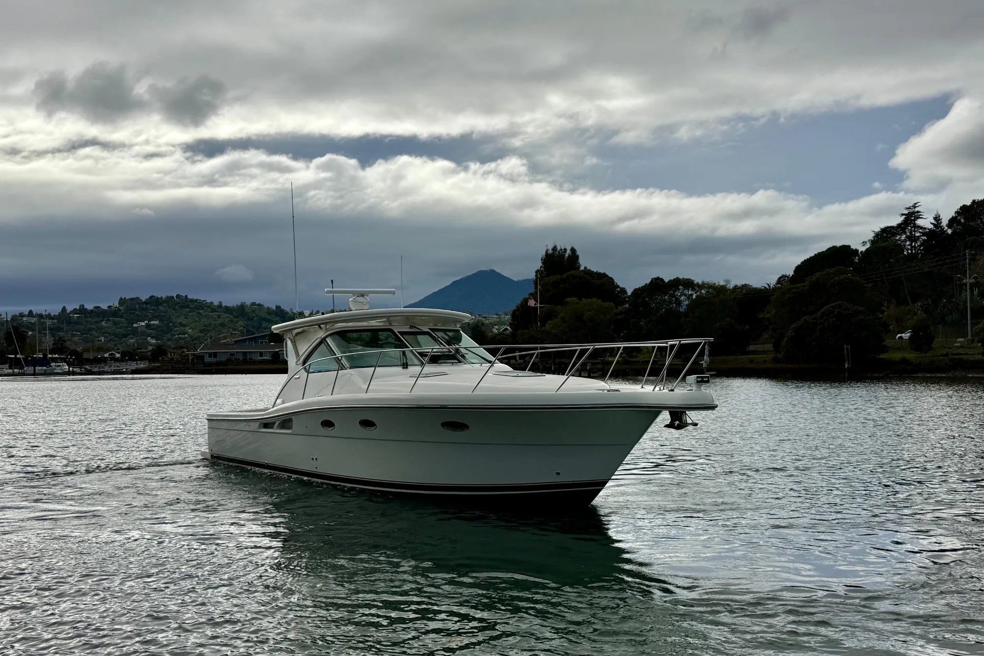 2005 Tiara 3600 Open yacht cruising on a calm lake under cloudy skies.