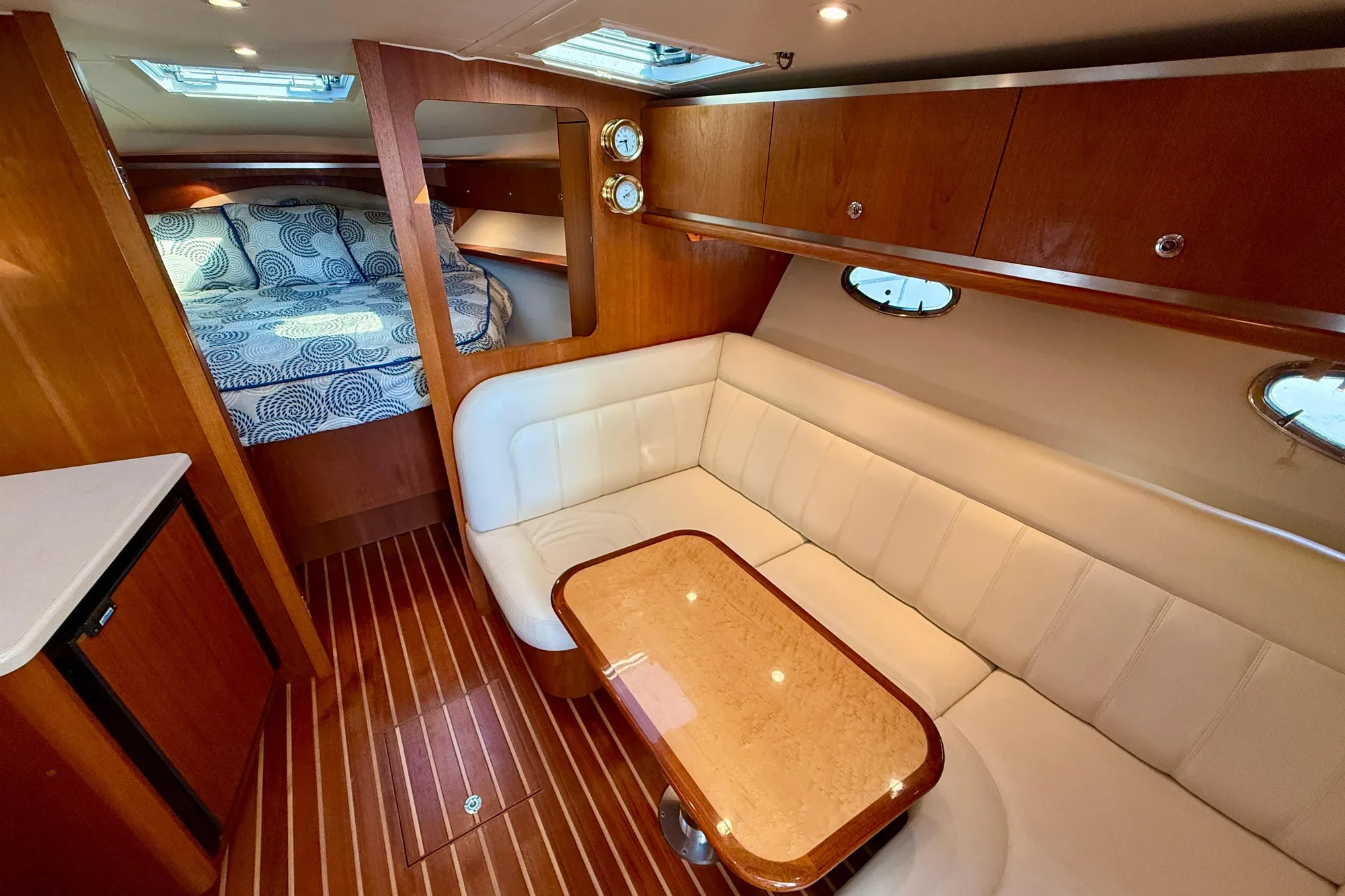 Luxurious interior of 2005 Tiara Yachts 3600 Open with cozy seating and elegant wood finishes.