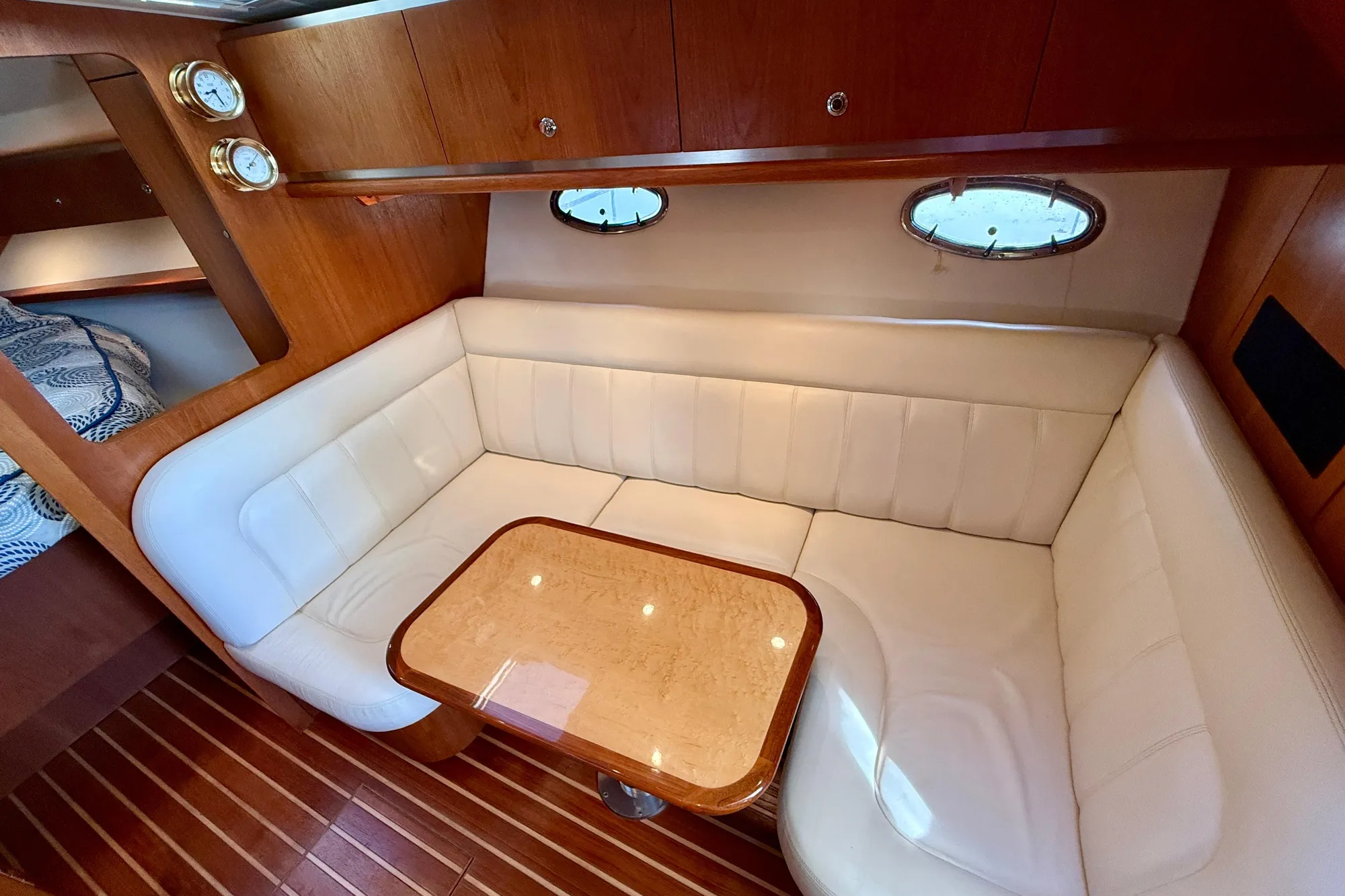 Luxurious interior of 2005 Tiara Yachts 3600 Open with white seating and wooden accents.