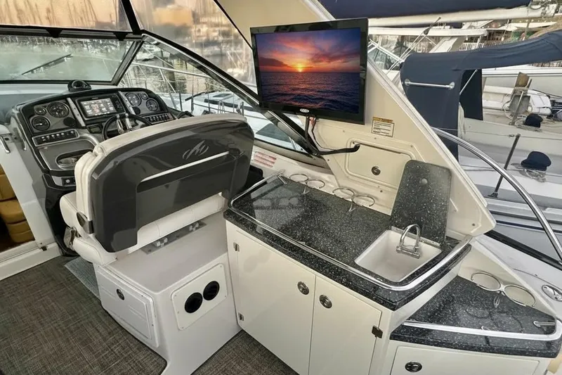 Favorite Mistake Yacht Photos Pics Cockpit of 2013 Monterey 400 Sport Yacht with helm, sink, and TV displaying sunset.
