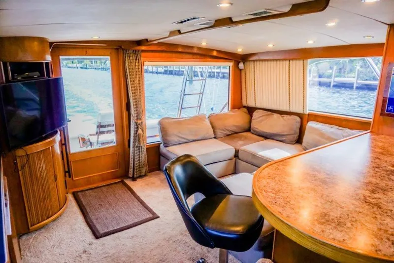 Wonderer Yacht Photos Pics Interior of a 1987 Bertram 54 Convertible yacht with cozy seating and elegant wood finishes.