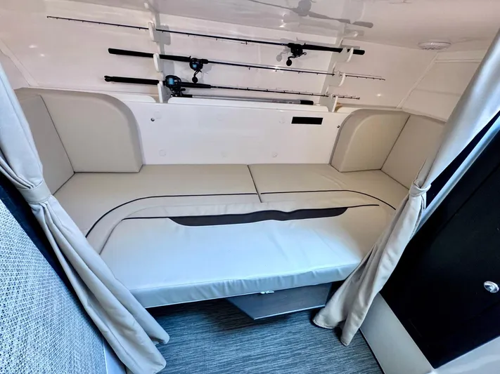 Seanior Moment Yacht Photos Pics 2022 Stamas 370 Aegean cabin interior with fishing rods and cushioned seating.