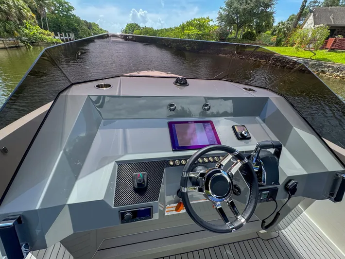  Yacht Photos Pics 2024 De Antonio Yachts D28 Open helm with modern controls on a scenic waterway.